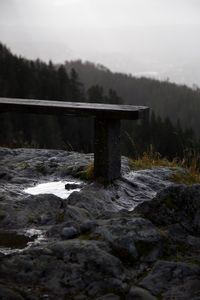 Bridge over stream against sky during winter