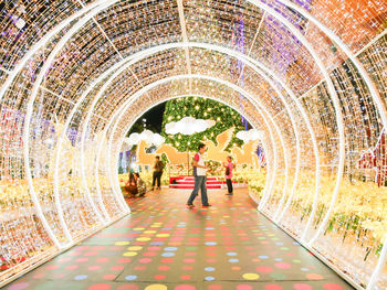 People in illuminated tunnel