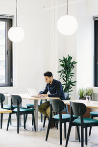 Businessman using laptop computer while sitting at desk in office