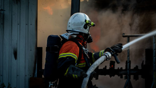 Firefighter spraying water on fire