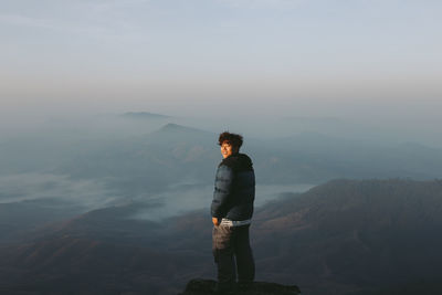 Man standing on mountain against sky