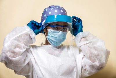 Doctor wearing mask against blue background