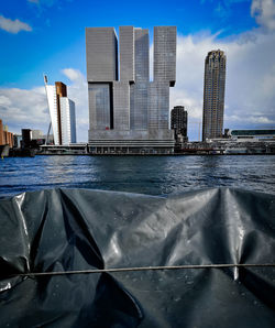 Modern buildings by sea against sky in city