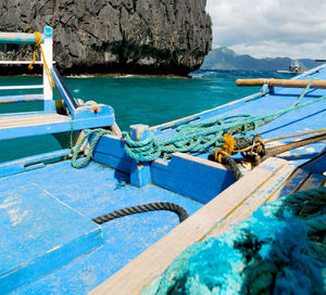 Boats moored in sea against blue sky