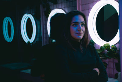 Portrait of young woman standing at night