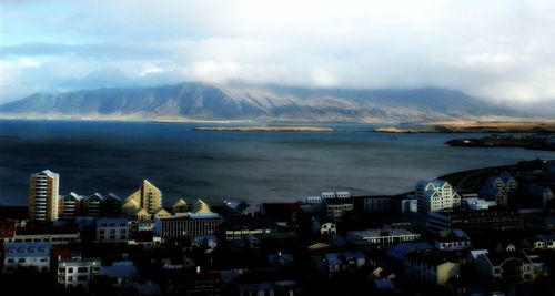 View of cityscape against cloudy sky