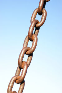 Close-up of rusty chain against clear blue sky