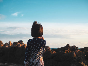 Rear view of girl standing at beach