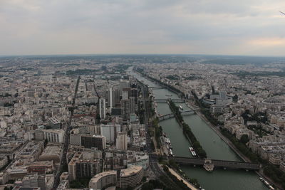 High angle view of city by river against sky