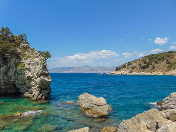 Scenic view of rocks in sea against blue sky