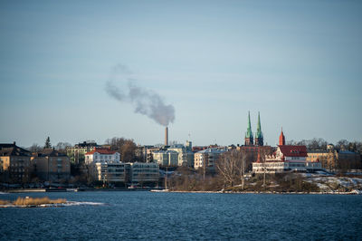 Distant view of st john church in city by sea against sky