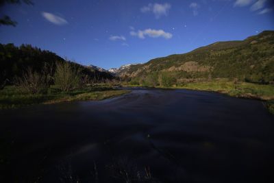 Scenic view of road by mountains against sky