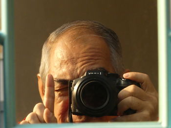 Reflection of man photographing in mirror