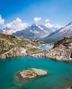 Scenic view of lake and mountains against blue sky