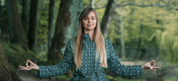 Close-up of woman doing yoga against trees