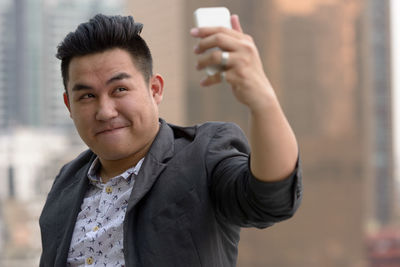 Portrait of man doing selfie in city