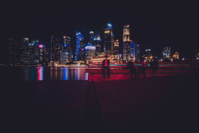 Illuminated buildings against sky at night