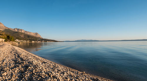 Scenic view of beach against blue sky