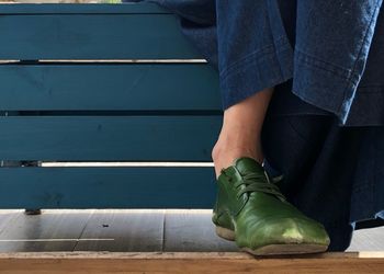 Low section of man standing on wood