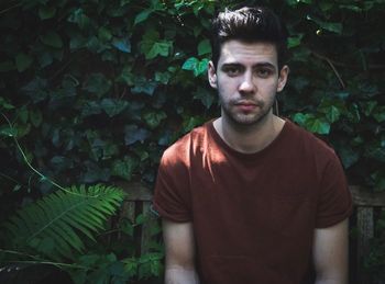 Portrait of handsome young man against plants