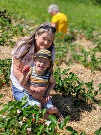 Portrait of smiling grandson and grandmother on field