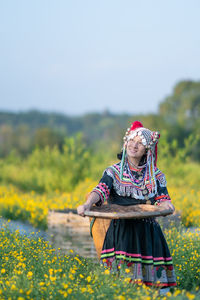 Woman with umbrella standing on field