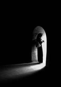 Woman standing at entrance in darkroom