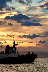 Silhouette ship on sea against sky during sunset