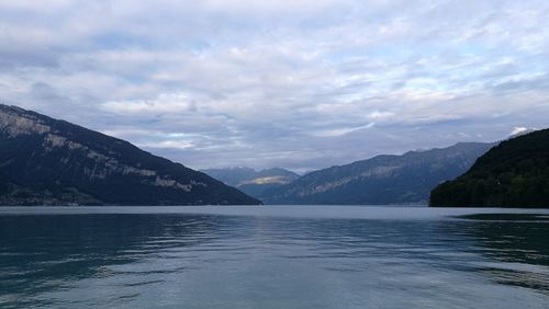 Scenic view of lake by mountains against sky