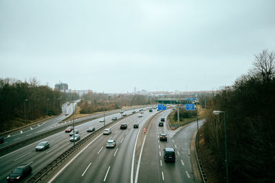 Vehicles on road in city against sky