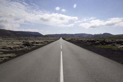 Empty road with mountains in background