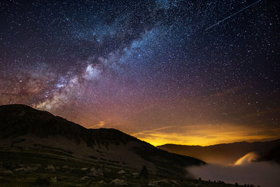 Scenic view of mountains against sky at night