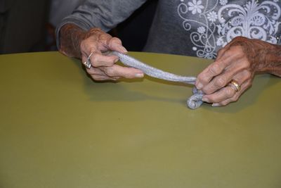 Midsection of woman holding slime at table