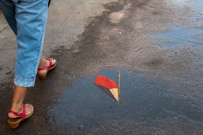 Low section of woman walking on road