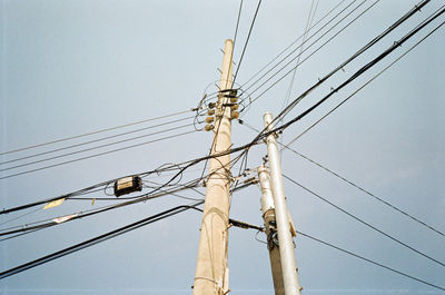 Low angle view of electricity pylon against clear sky