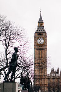 Low angle view of clock tower amidst buildings in city