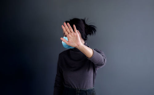 Midsection of woman standing against gray background