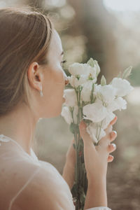 Portrait of woman holding white flower