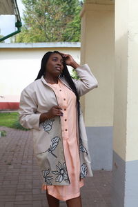 Young woman looking away while standing on road