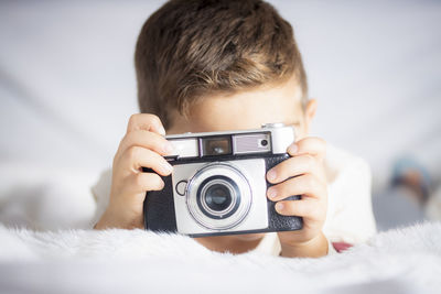 Portrait of boy photographing through camera