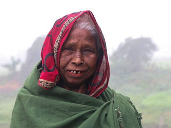 Portrait of smiling elderly woman in a foggy morning.