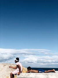 Woman on beach against blue sky