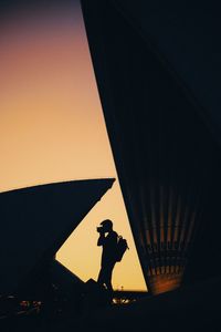 Silhouette man standing against clear sky at sunset