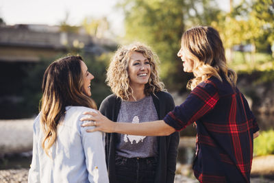 Happy female friends talking standing outdoors