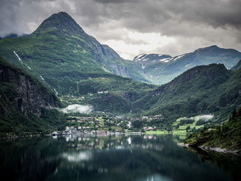 Scenic view of river and mountains against sky