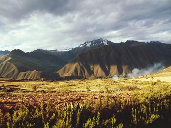 Scenic view of mountains against cloudy sky