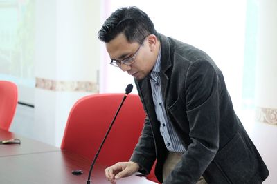 Businessman speaking on microphone at office