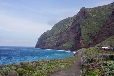 Scenic view of sea and mountains against sky