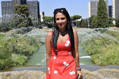 Portrait of smiling woman standing against plants