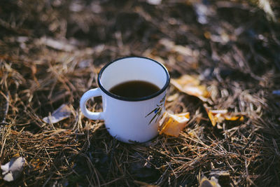 Close-up of coffee cup on field